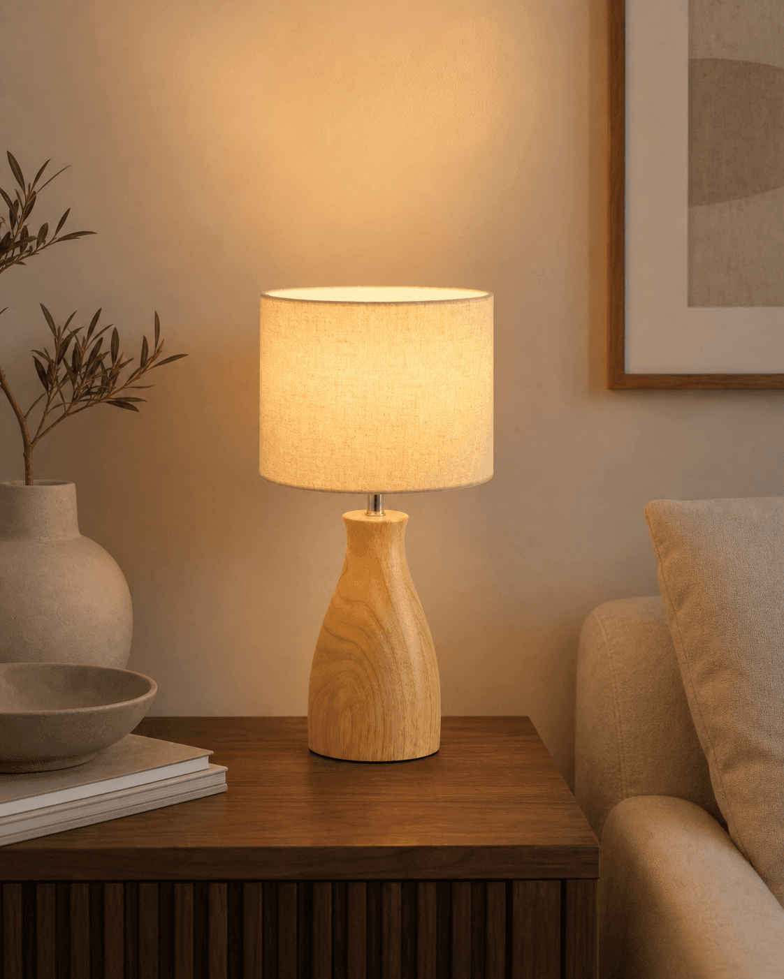 Linen shade table lamp with a solid wood base on a side table